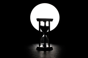 Hourglass with a flowing blue sand inside	