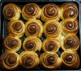 A tray of freshly baked cinnamon buns on a baking sheet