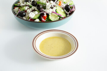 A view of a condiment cup of a Greek vinaigrette.