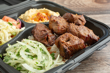 A closeup view of a beef kebab combo plate.