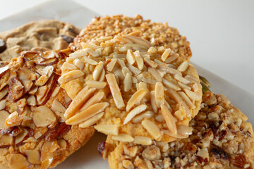 A view of a pile of cookies, featuring almond toppings.