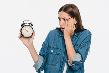 Time is running out. Irritated shocked woman in yellow shirt putting hand on head cheek holding...