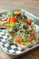 A closeup view of avocado toast, on a metal tray.