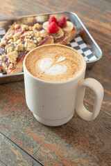A view of a latte and a peanut butter and jelly tartine.