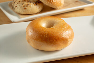 A view of a plain bagel, on a plate.