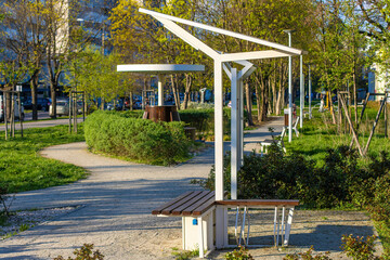 A modern bench with solar panels on the roof and USB input for charging mobile devices, located in...