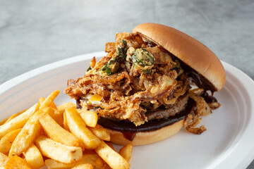 A view of a fried onion and jalapeno burger.