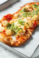 A closeup view of a chicken parmesan flatbread.