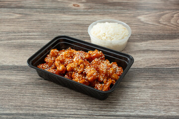 A view of a container orange chicken, with a side of white rice.