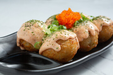 A closeup view of a plate of takoyaki.
