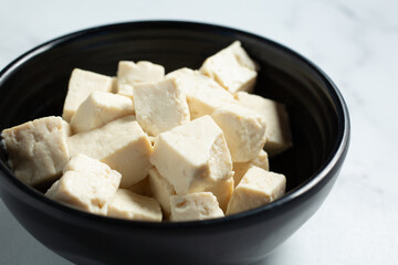 A closeup view of a bowl of chopped tofu.