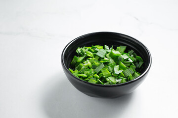 A view of a condiment cup of chopped nira.