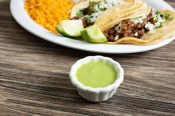 A view of a condiment cup of avocado salsa.