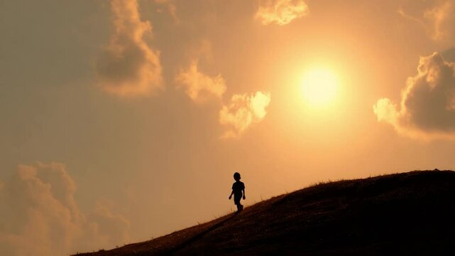 Silhouette of Solitude: A solitary figure, silhouetted against a breathtaking sunset, embarks on a journey, climbing a hill, a visual ode to perseverance and determination.