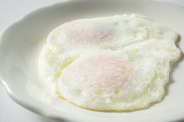 A view of over medium eggs, on a plate.
