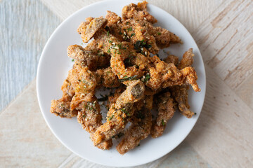 A top down view of a plate of gluten-free fried shimeji mushrooms.