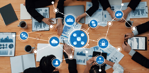 A dynamic business meeting showcasing collaboration over data charts and technology symbols,...