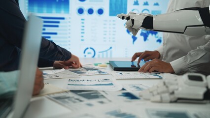 A collaborative workspace featuring human and robot hands working together on data analysis, showcasing modern technology and visual metrics to enhance productivity.Noogenesis