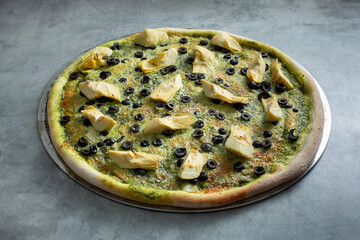 A view of an olive artichoke pesto pizza.