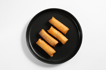 A top down view of a plate of egg rolls.