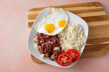 A top down view of a plate of Filipino corned beef breakfast.