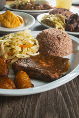 A view of a plate of jerk salmon, among other entrees.