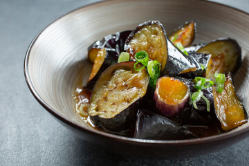 A closeup view of a bowl of miso glazed eggplant.