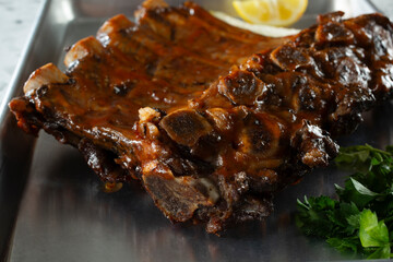 A closeup view of a tray of BBQ beef ribs.