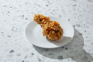 A view of an extra crispy fried chicken drumstick, on a plate.