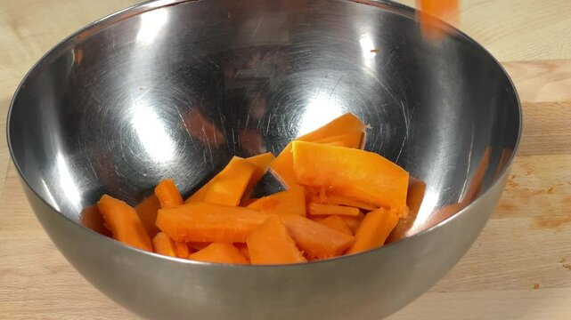 A professional chef throws vegetables into a plate