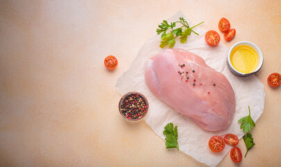 Fresh raw turkey fillet seasoned with peppercorns, cherry tomatoes, parsley, and oil on baking paper, perfect for a healthy meal top view, copy space