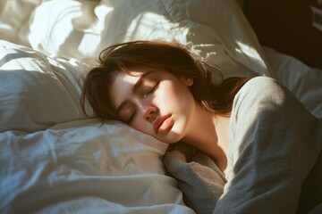 Woman sleeping peacefully in bed bathed in sunlight soft focus.