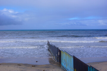 Mexico-United States border wall (also known as Trump wall) meets the Pacific Ocean in Tijuana, a...