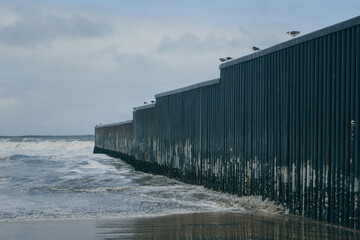 Mexico-United States border wall (also known as Trump wall) meets the Pacific Ocean in Tijuana, a...