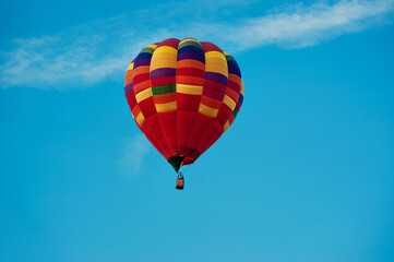 Multicolored ball in the blue sky. Sunlight highlights the bright edges and colors of the dome, space for inscriptions