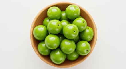 Top-Down View of Fresh Green Plums in a Wooden Bowl
