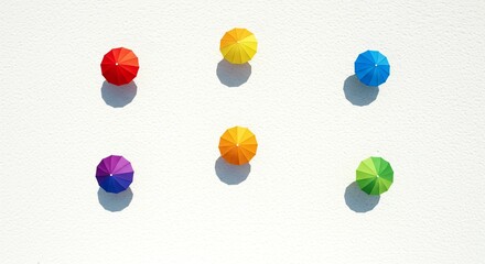 Fototapeta premium A vibrant scene of colorful, miniature umbrellas casting shadows on a bright surface, creating a playful, summer-themed abstract composition.