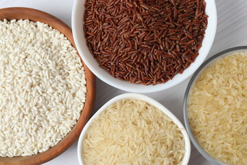 Different types of rice in bowls on table, closeup