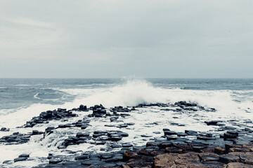 Storm Waves Crash Against the Giant’s Causeway Rocks with Dark Skies	