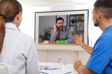 Obraz premium Speaker participating in lecture via online video chat. Medical workers in conference room with projection screen
