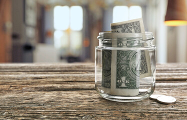 Tips jar with money on wooden table in cafe, space for text
