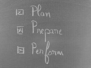 A chalkboard with 'Plan, Prepare, Perform' is checked, demonstrating a list of tasks and their...