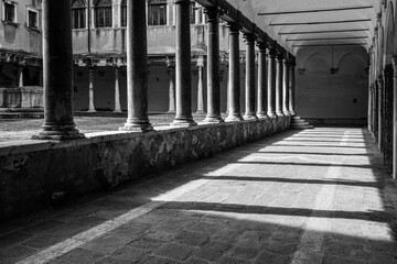 Black and white. Cloister of the church of Santo Stefano (1529), surrounded by a porch with ionic columns, Venice, Veneto, Italy