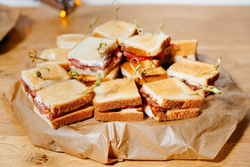 Stack of toasted mini meat sandwiches.