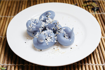 Blue Thai dessert dumplings with coconut topping.