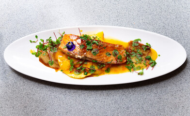Salmon filet with mango puree and herbs.