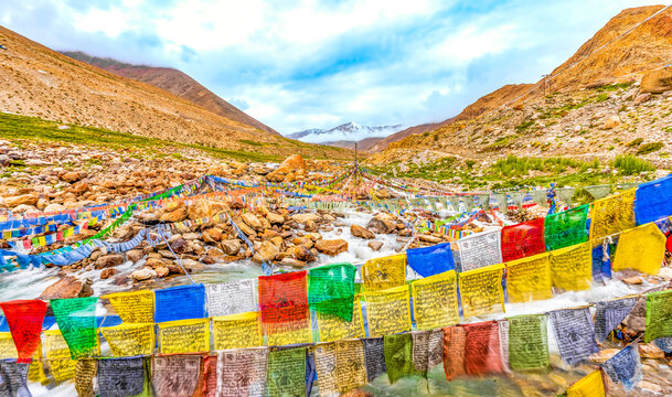 Ladakh, India. Mountain river rushing under prayer flags down from the Himalayan Mountains.