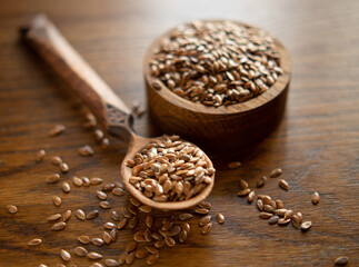 flax seeds in a rustic wooden bowl on a wooden table with copy space