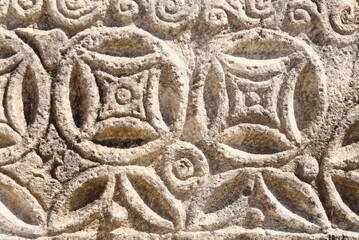 Stone carving border section in ancient city ruins. Ancient art textured background. Stone carving texture. Background for designs.Ancient stone carving, geometric and floral patterns. In Bodrum. 