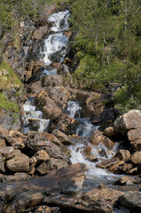 A scenic photo from Norway showing a cascading mountain stream flowing over rugged rocks.